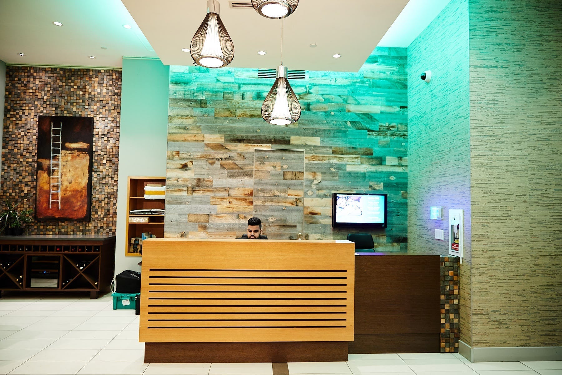 Uniformed Blackbird security guard sitting at reception desk in front of screen