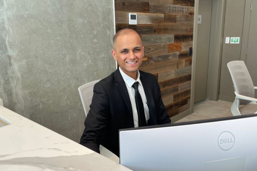 Uniformed Blackbird security guard sitting at reception desk in front of screen