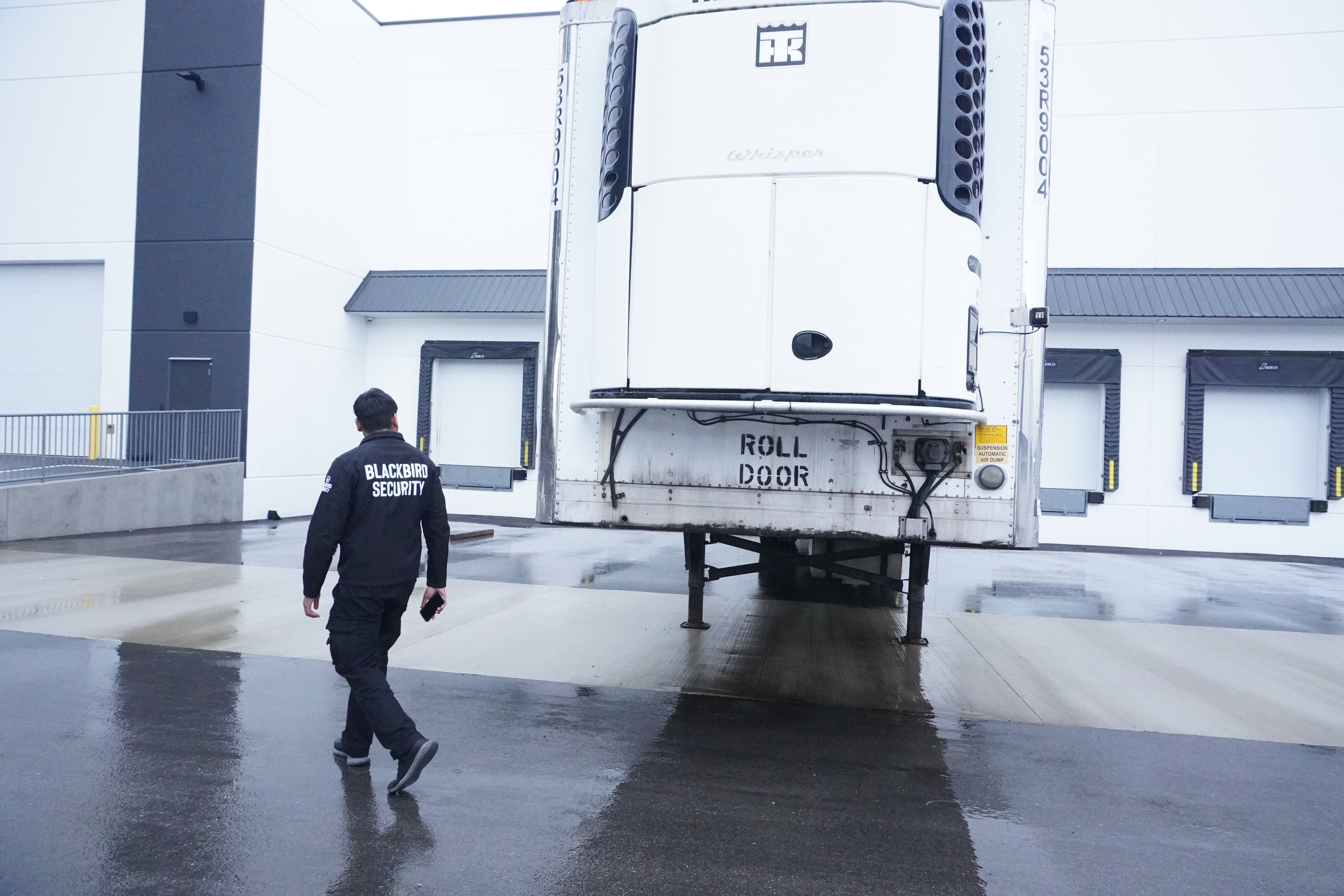 A Blackbird Security guard inspects a truck at a warehouse