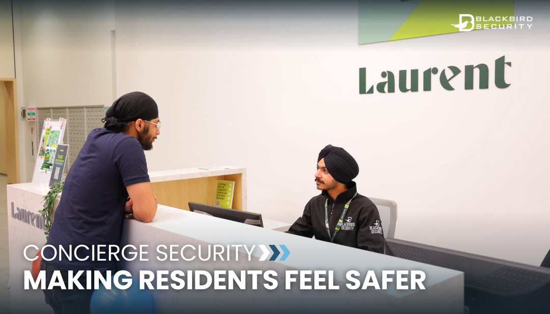 Concierge security guard speaking with a resident at a building's front desk.