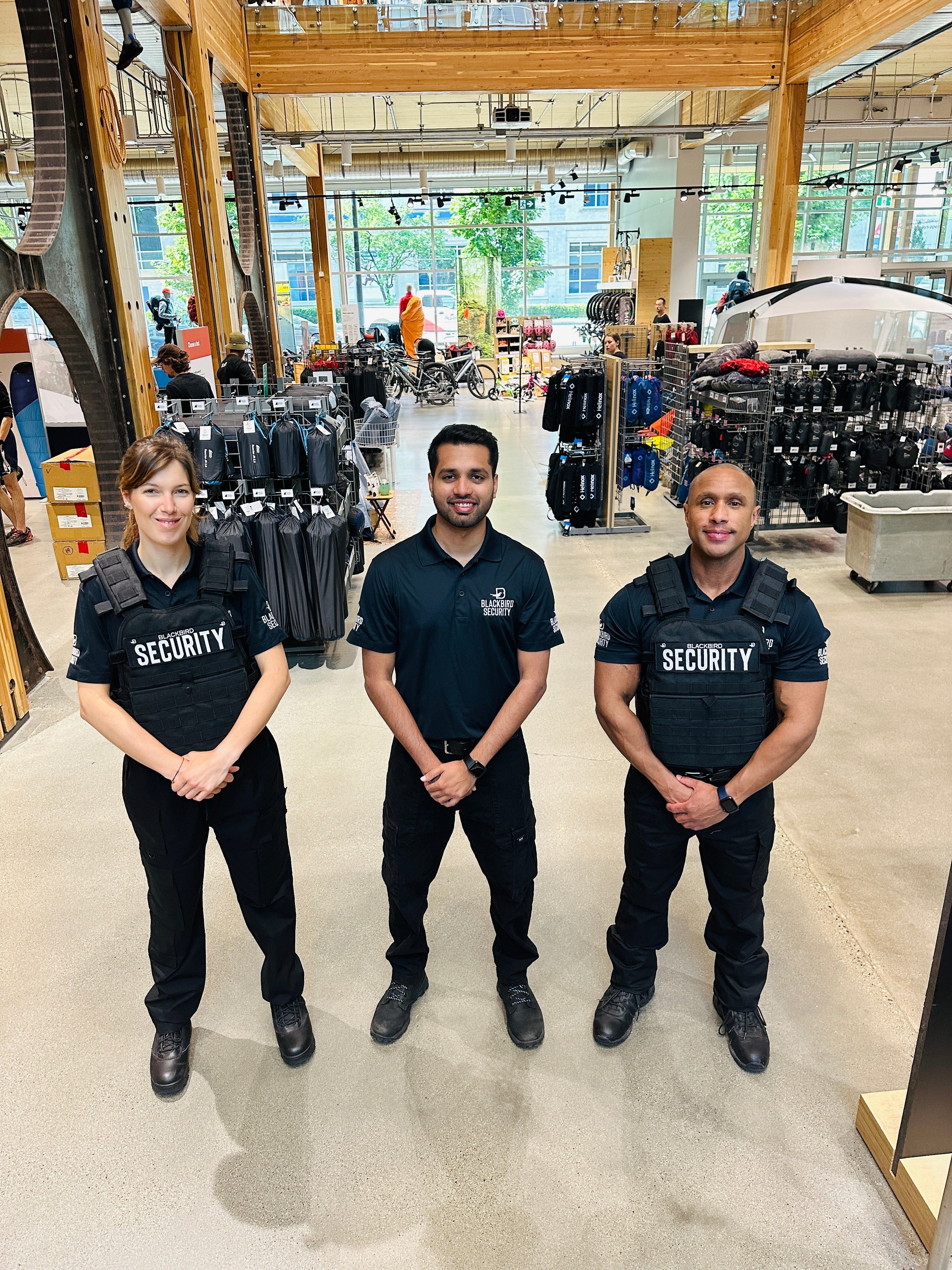 Three Uniformed Blackbird security guards standing in retail location