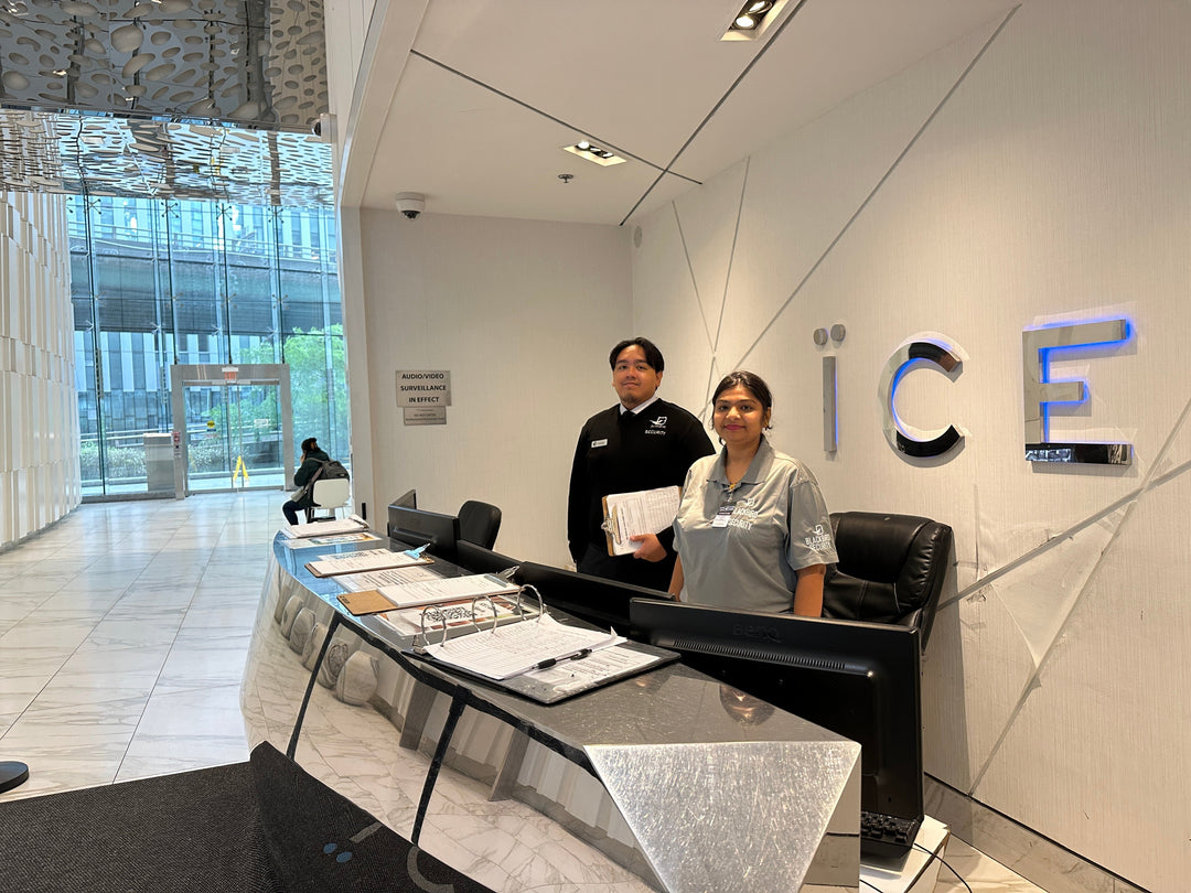Two condo security guards stand at a front desk