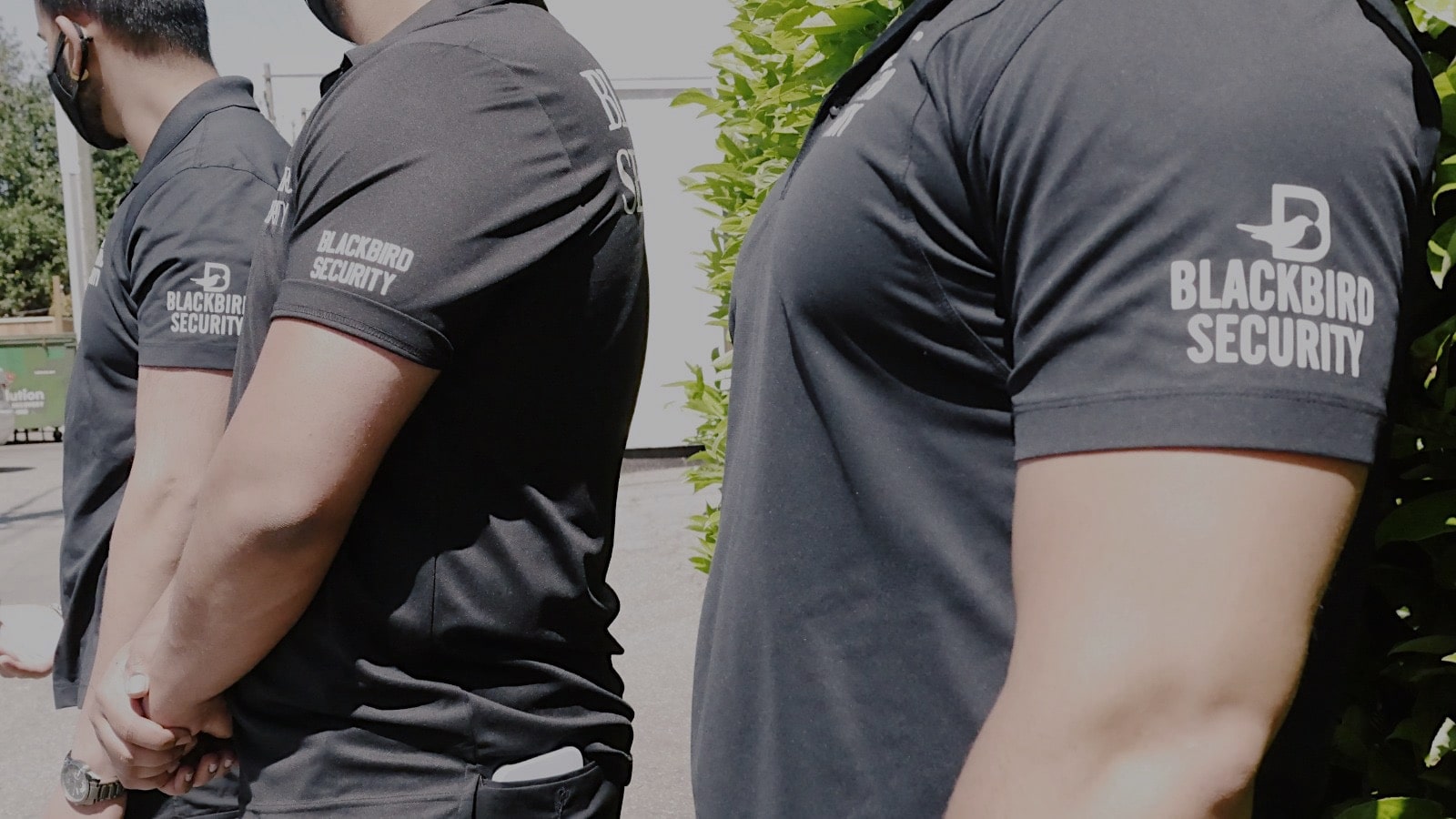 Three Uniformed Blackbird security guards standing together outside