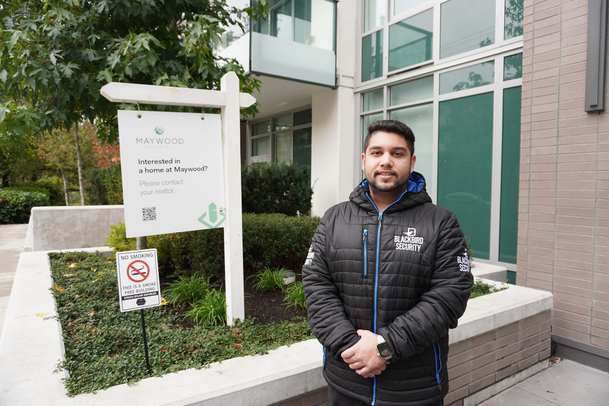 Uniformed Blackbird security guards standing in front of building with signs