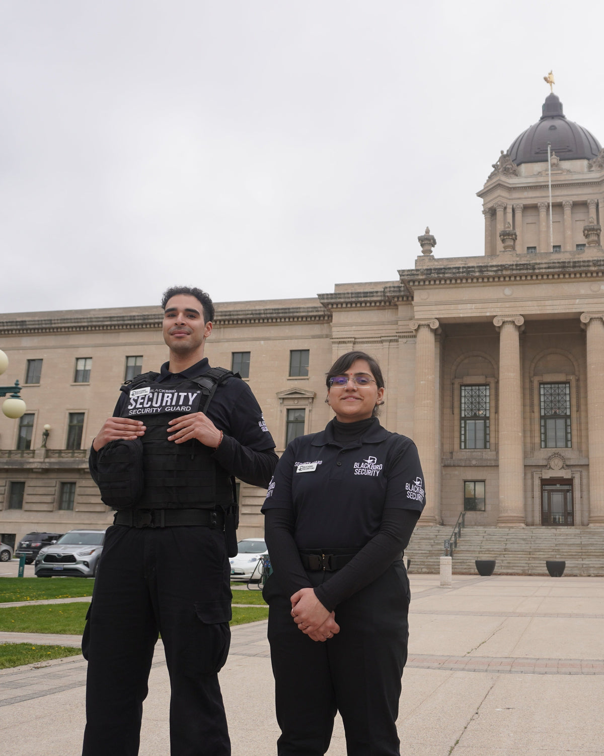 Two Uniformed Blackbird security guards standing in front of building