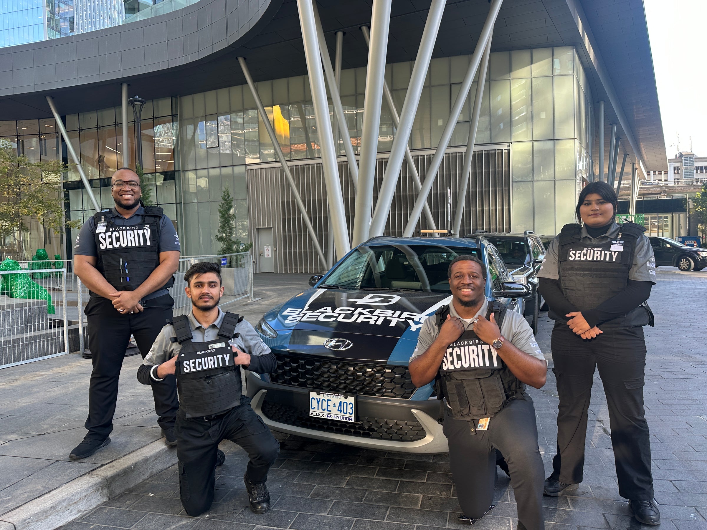 Four Uniformed Blackbird security guards in front of Mobile patrol car
