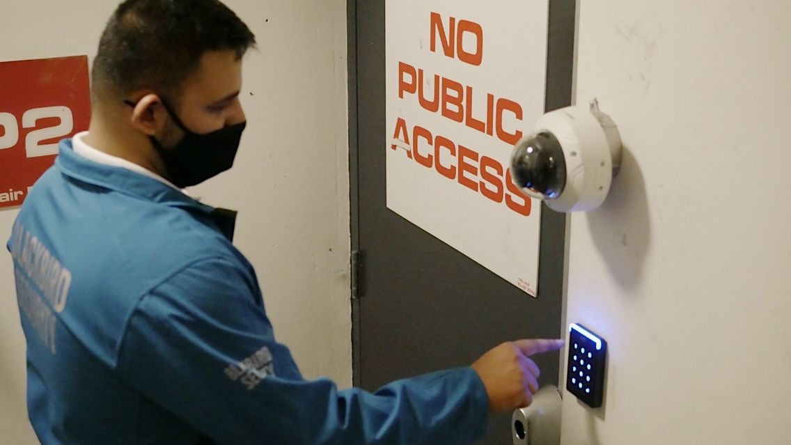 Blackbird Security guard enters a pin on a keypad with a door that says "No Public Access" in the background.