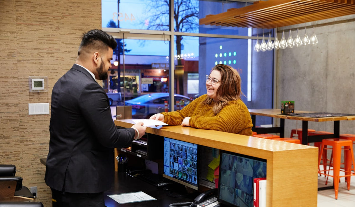 Blackbird Security concierge assisting a client at a reception desk